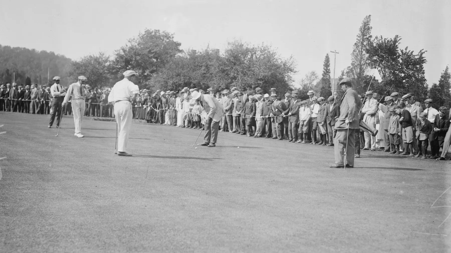 Harry Vardon and other golfers on a green before a large crowd in the United States